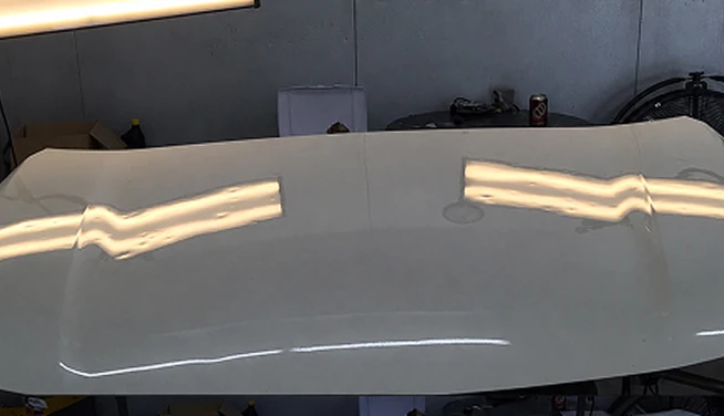 Light-colored hood under inspection lighting, before repair — Alpha Hail Repair, Springfield, Missouri