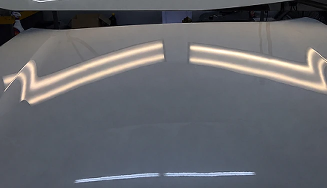 Light-colored hood under inspection lighting, after repair — Alpha Hail Repair, Springfield, Missouri