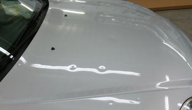 Silver hood with dents visible in reflected light, before repair — Alpha Hail Repair, Springfield, Missouri